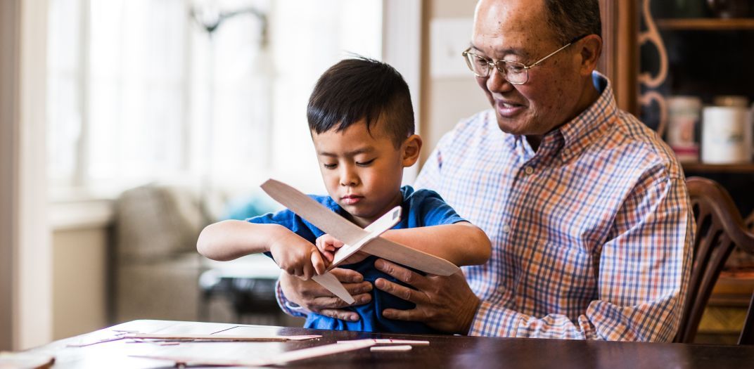 Man building airplane with child