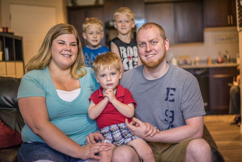 Family of five sit on a couch