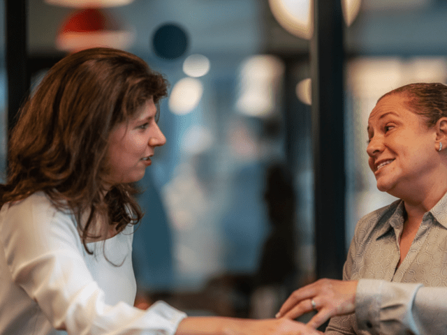 Two women sitting at a table talking